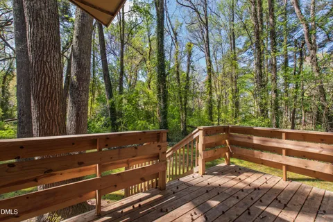 an aerial view of residential house with outdoor space and trees all around