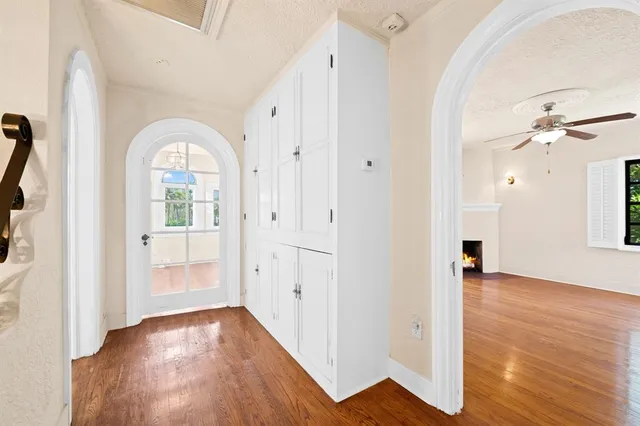 a view of a hallway with wooden floor and a bathroom