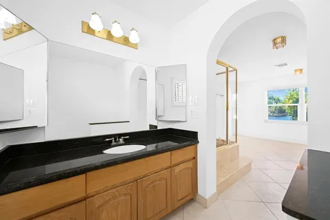 a bathroom with a granite countertop sink a vanity and a mirror