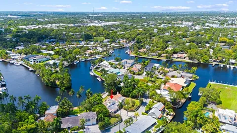 an aerial view of residential houses with outdoor space and trees