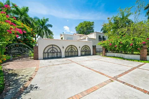 a white house with a yard and potted plants