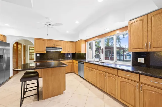 a kitchen with stainless steel appliances granite countertop a refrigerator and a stove top oven