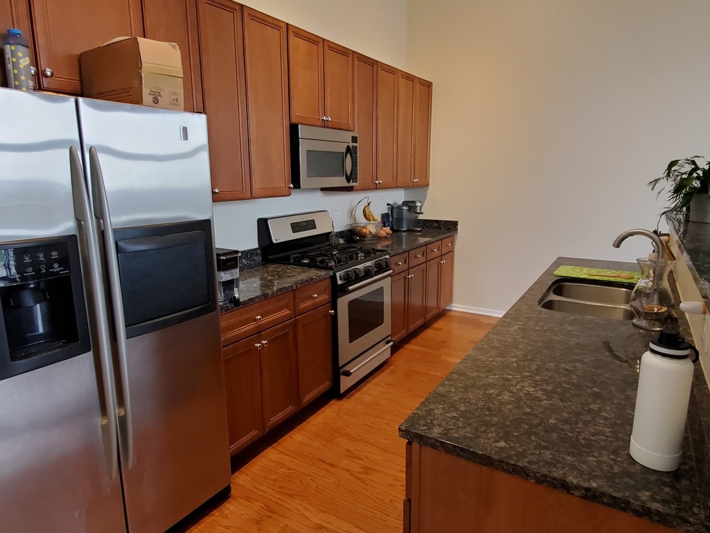 1525 South Sangamon Street, Unit 802P Chicago, IL 60608 - Photo 11 of 32 a kitchen with stainless steel appliances granite countertop a sink a stove a refrigerator a washer dryer and white cabinets