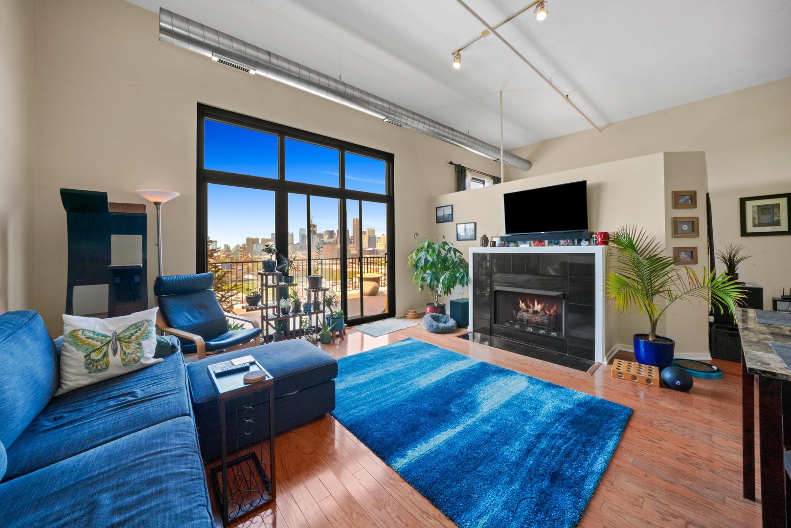 1525 South Sangamon Street, Unit 802P Chicago, IL 60608 - Photo 14 of 32 a living room with furniture a flat screen tv and a fireplace