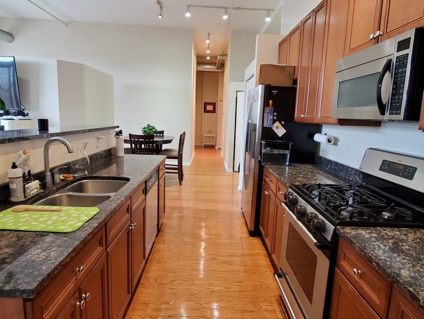 1525 South Sangamon Street, Unit 802P Chicago, IL 60608 - Photo 10 of 32 a kitchen with kitchen island granite countertop a sink a counter top space stove and cabinets