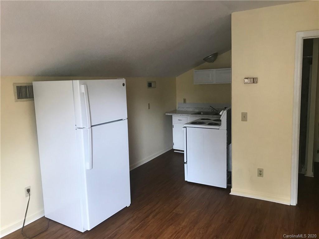 116 Walnut Street, Unit A Monroe, NC 28110 - Photo 2 of 5 a kitchen with a refrigerator and a stove top oven