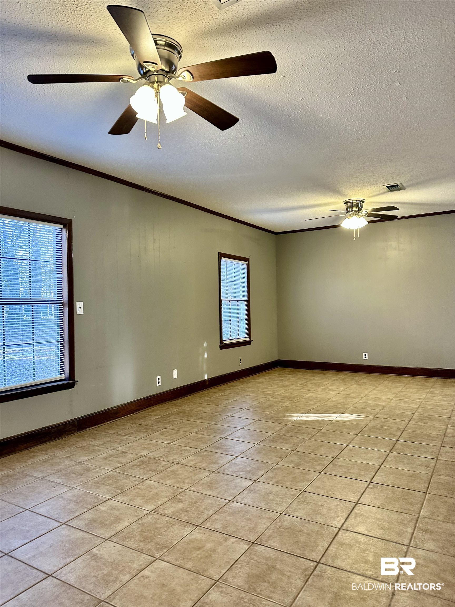2664 Sowell Road Brewton, AL 36426 - Photo 7 of 12 Tiled spare room with ceiling fan, a textured ceiling, and crown molding