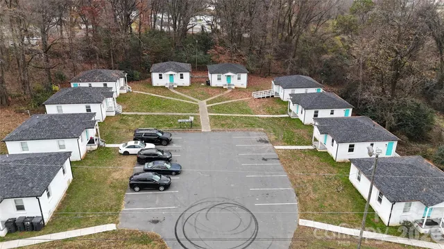 a view of a tennis ground with large trees