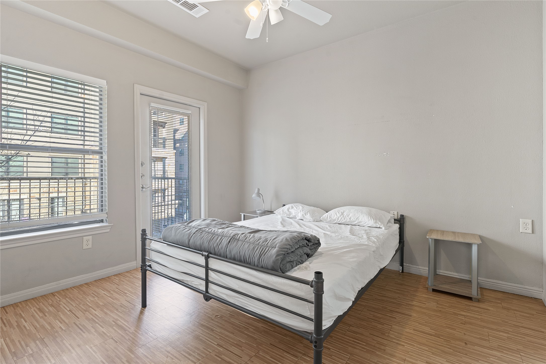 2515 Pearl Street, Unit 314 Austin, TX 78705 - Photo 3 of 17 Bedroom with access to exterior, light wood-style flooring, and a ceiling fan