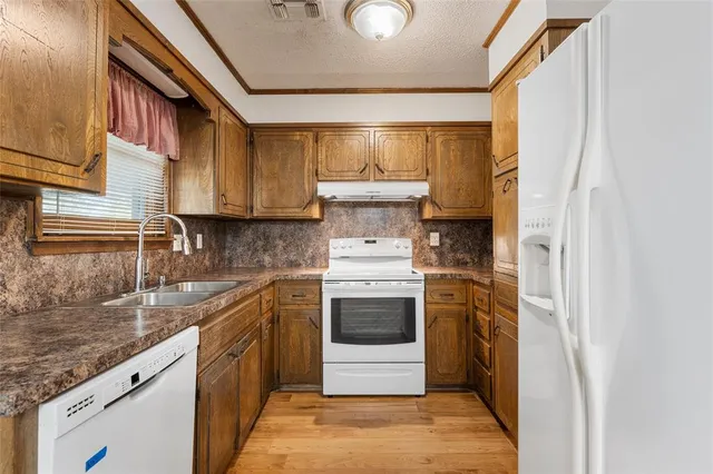 a kitchen with a stove sink and cabinets