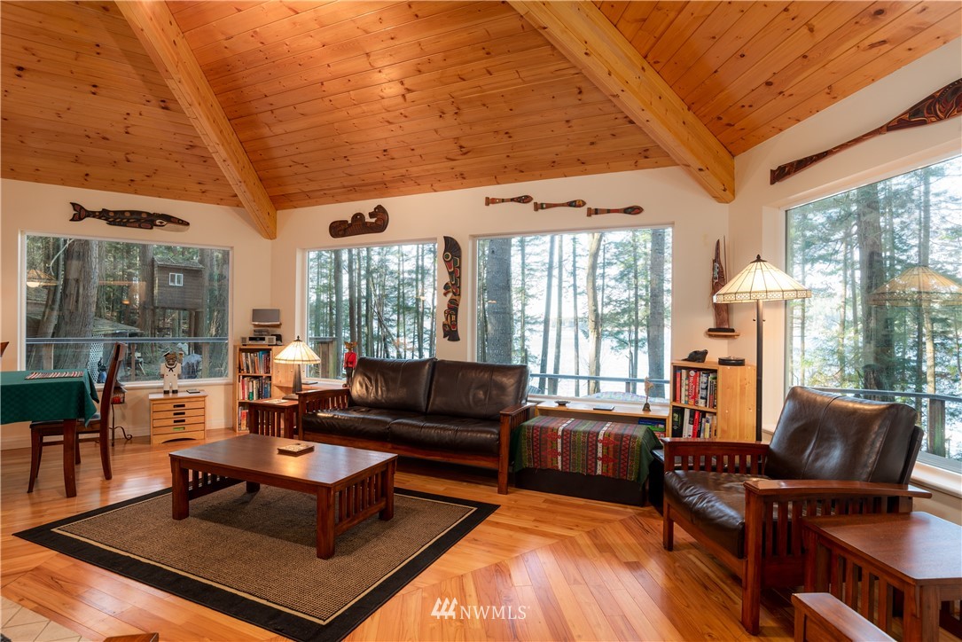 54 West Beach Path Olga, WA 98279 - Photo 11 of 39 a living room with furniture a wooden floor and a large window
