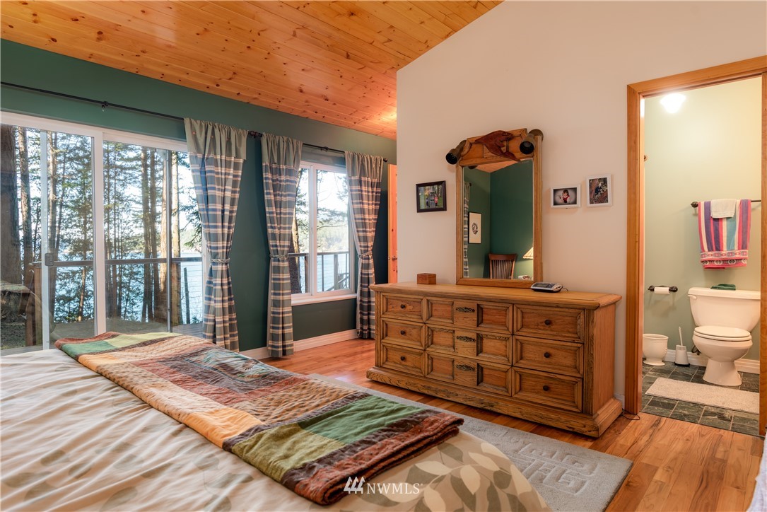 54 West Beach Path Olga, WA 98279 - Photo 13 of 39 a spacious bedroom with a bed a dresser and large windows