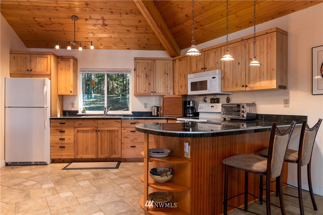 54 West Beach Path Olga, WA 98279 - Photo 4 of 39 a kitchen with granite countertop a sink appliances cabinets and a counter top space