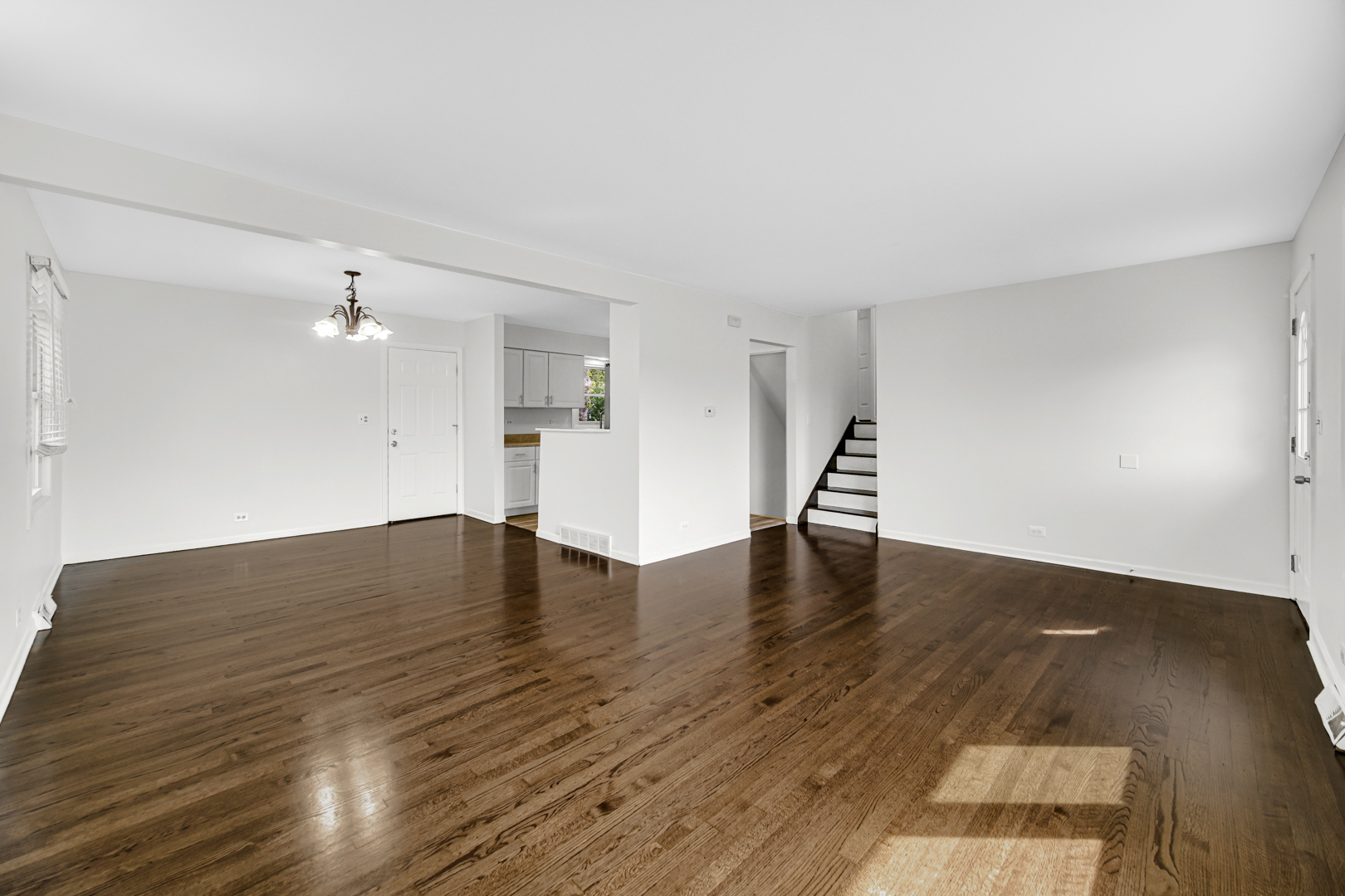 214 Oakleaf Road Lake In The Hills, IL 60156 - Photo 11 of 25 a view of empty room with wooden floor and kitchen