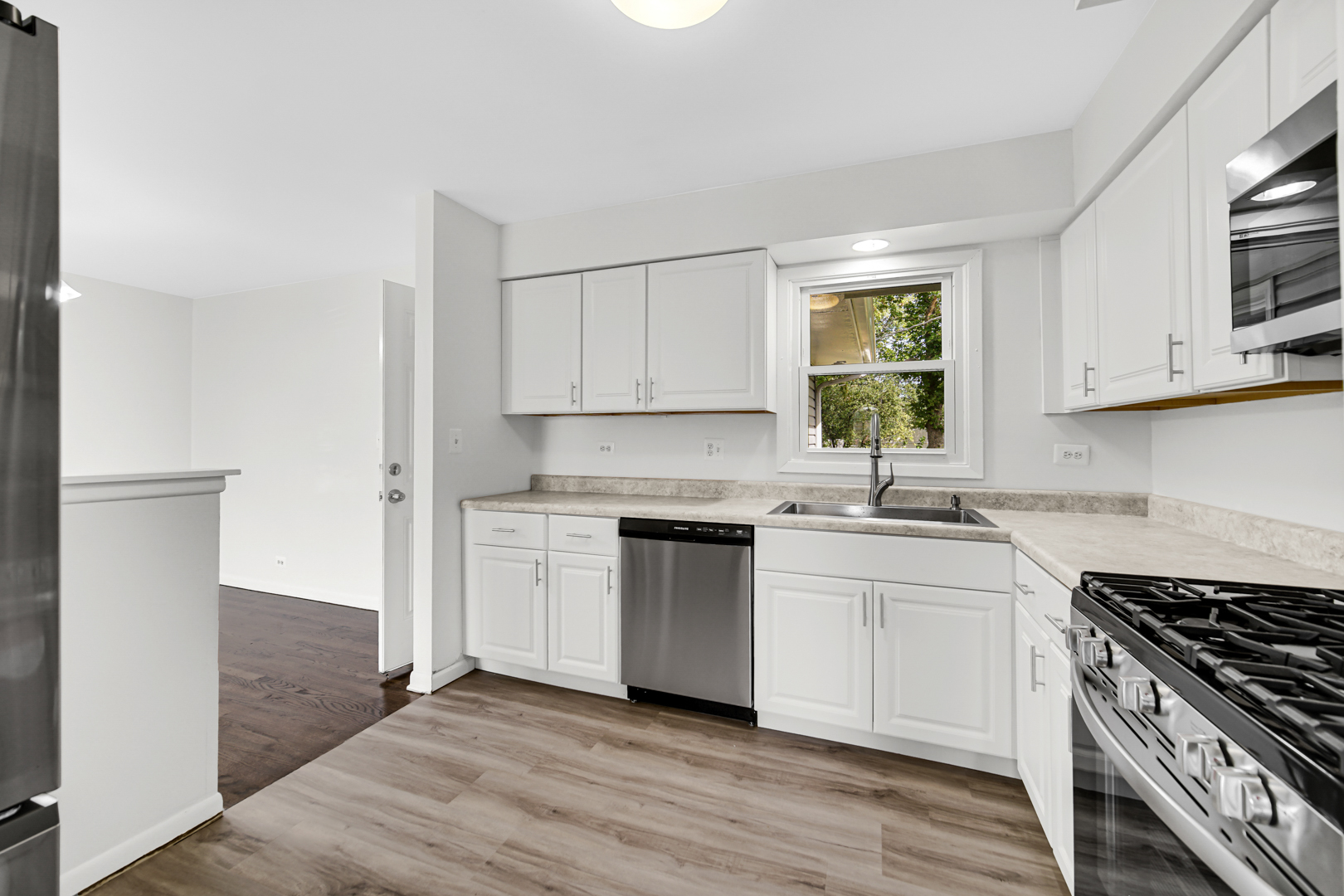 214 Oakleaf Road Lake In The Hills, IL 60156 - Photo 3 of 25 a kitchen with granite countertop white cabinets stainless steel appliances and a window