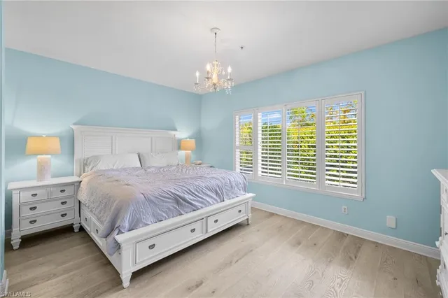 a bedroom with a large bed and a chandelier