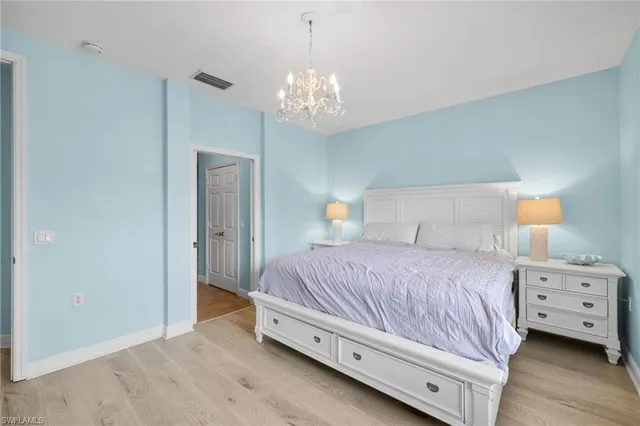 a bedroom with a bed and a chandelier