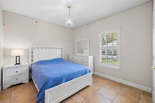 a bedroom with a large bed and a chandelier