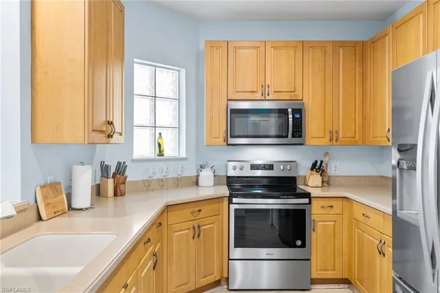a kitchen with stainless steel appliances a stove a sink a microwave and cabinets