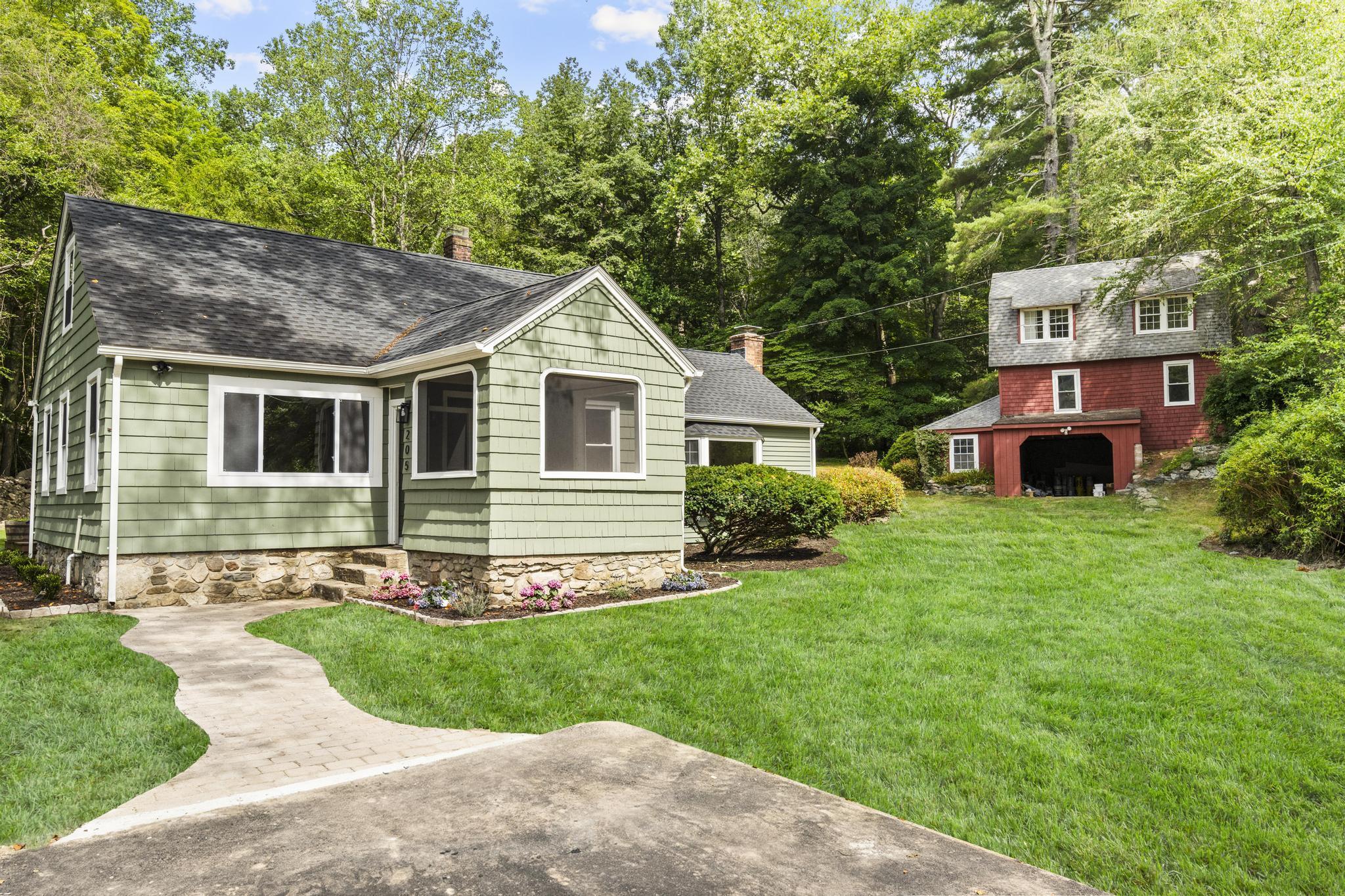 a front view of a house with a garden and yard
