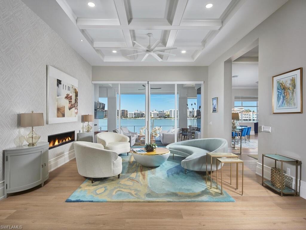 246 Mermaids Bight Naples, FL 34103 - Photo 4 of 16 a living room with fireplace furniture and a chandelier