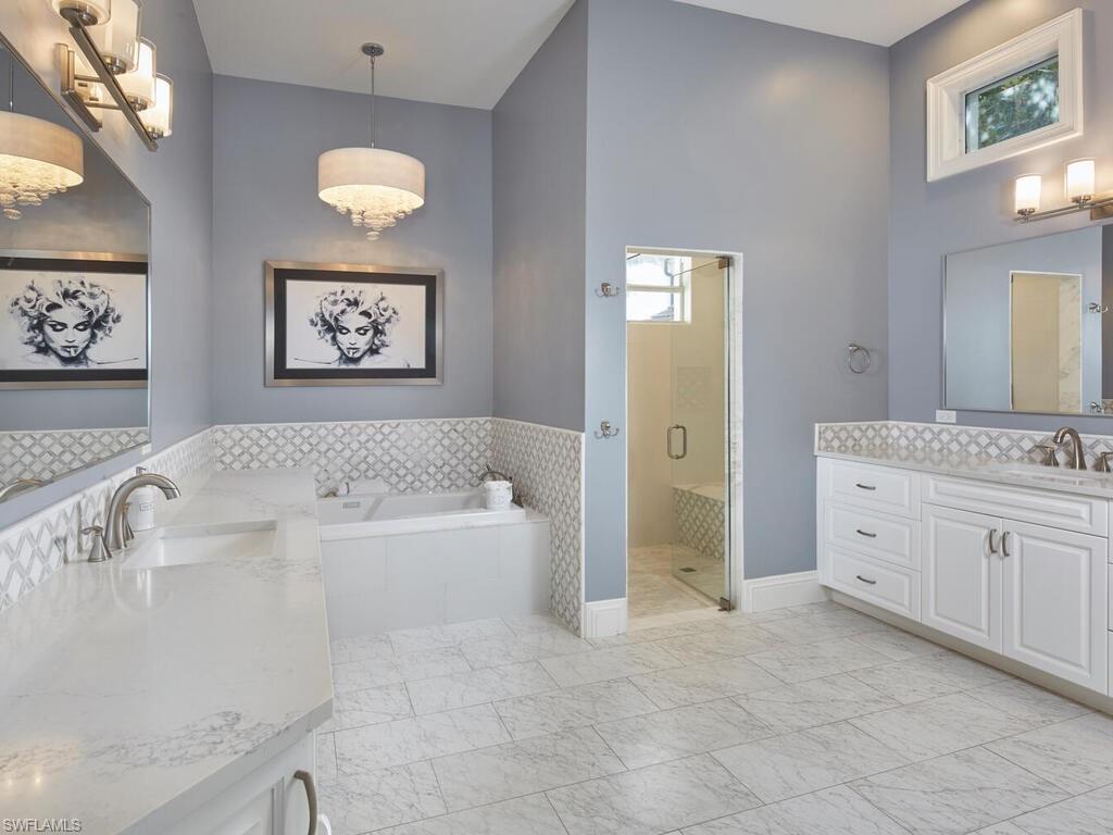 246 Mermaids Bight Naples, FL 34103 - Photo 8 of 16 a spacious bathroom with a tub sink and mirror