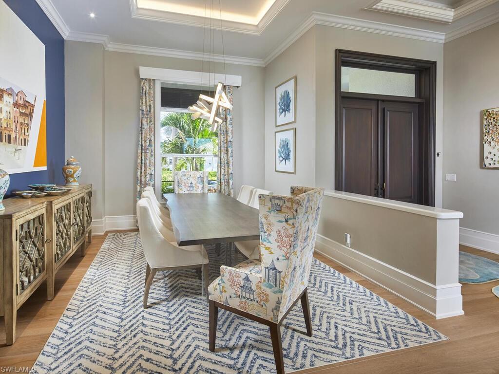 246 Mermaids Bight Naples, FL 34103 - Photo 9 of 16 a view of a dining room with furniture window and wooden floor