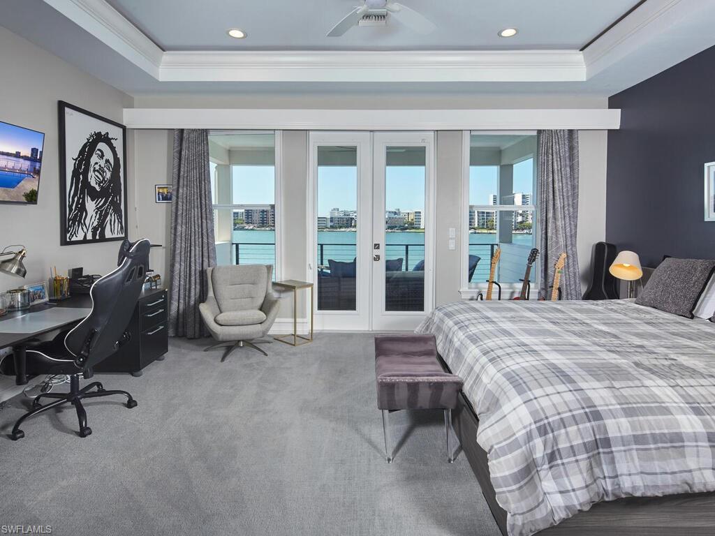 246 Mermaids Bight Naples, FL 34103 - Photo 10 of 16 a bedroom with a bed and a lounge chair