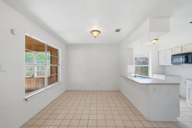 a view of an empty room with a fireplace and a window