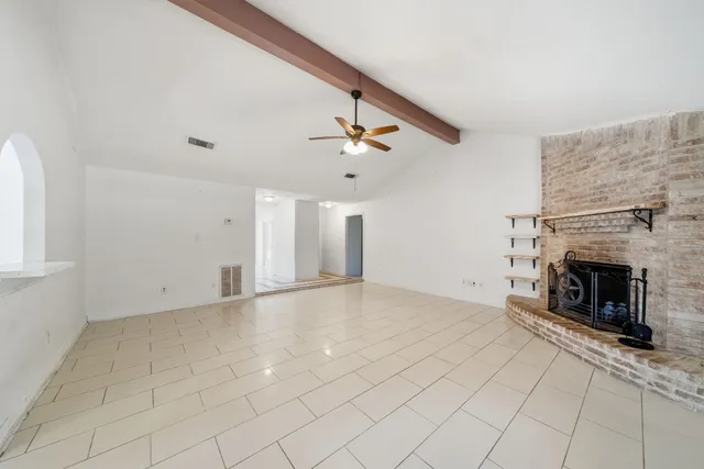 an empty room with fireplace and fan