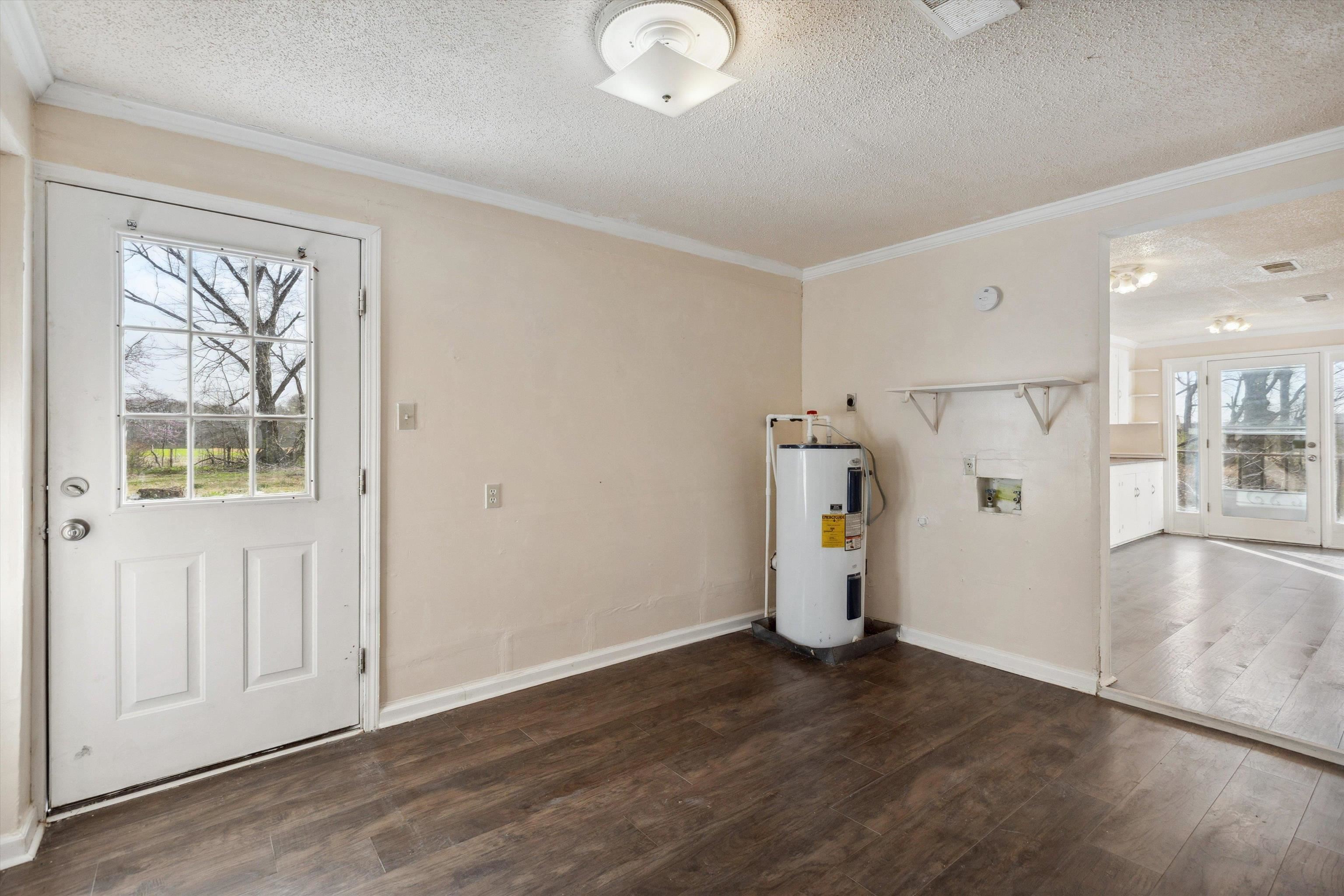 8457 East Kerrville Rosemark Road Millington, TN 38053 - Photo 15 of 32 Foyer with dark wood-type flooring, a textured ceiling, ornamental molding, and water heater