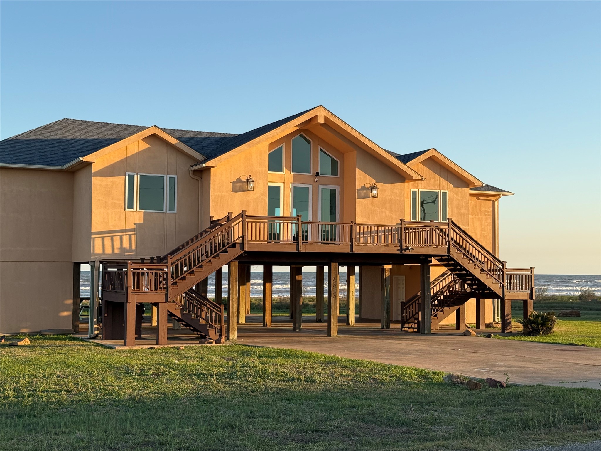 This elevated seaside home features spacious decks on both sides and large windows offering stunning ocean views.