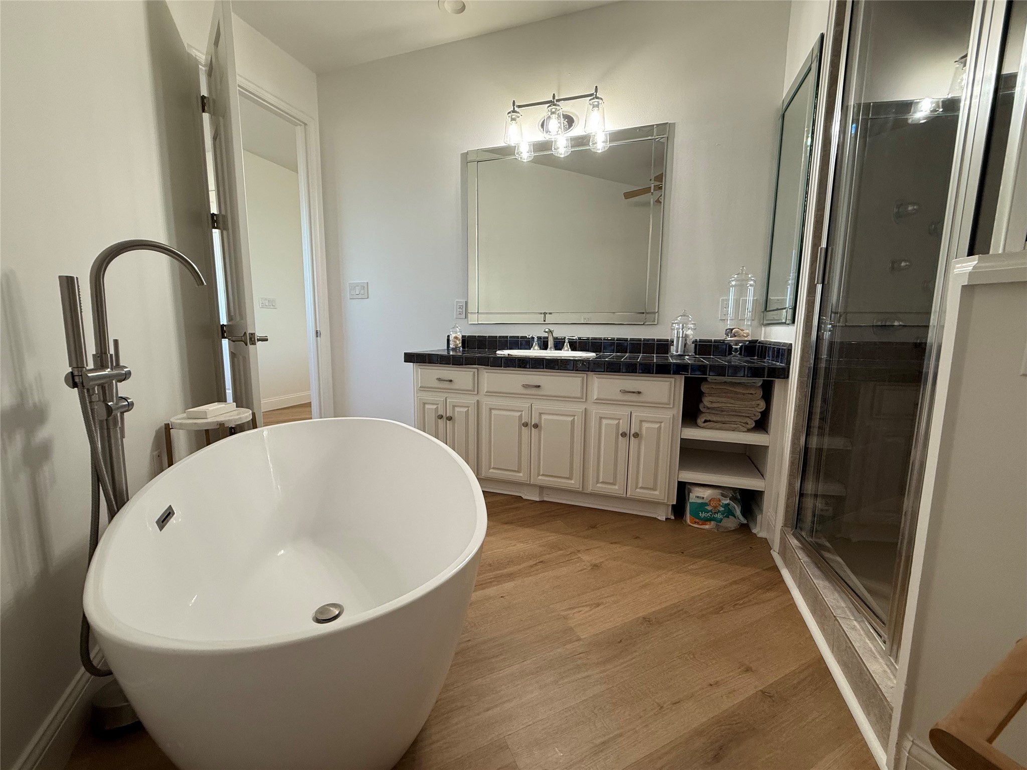 878 County Road 230 Sargent, TX 77414 - Photo 22 of 39 This bathroom features a modern freestanding bathtub, a spacious glass-enclosed shower, and a vanity with ample storage.