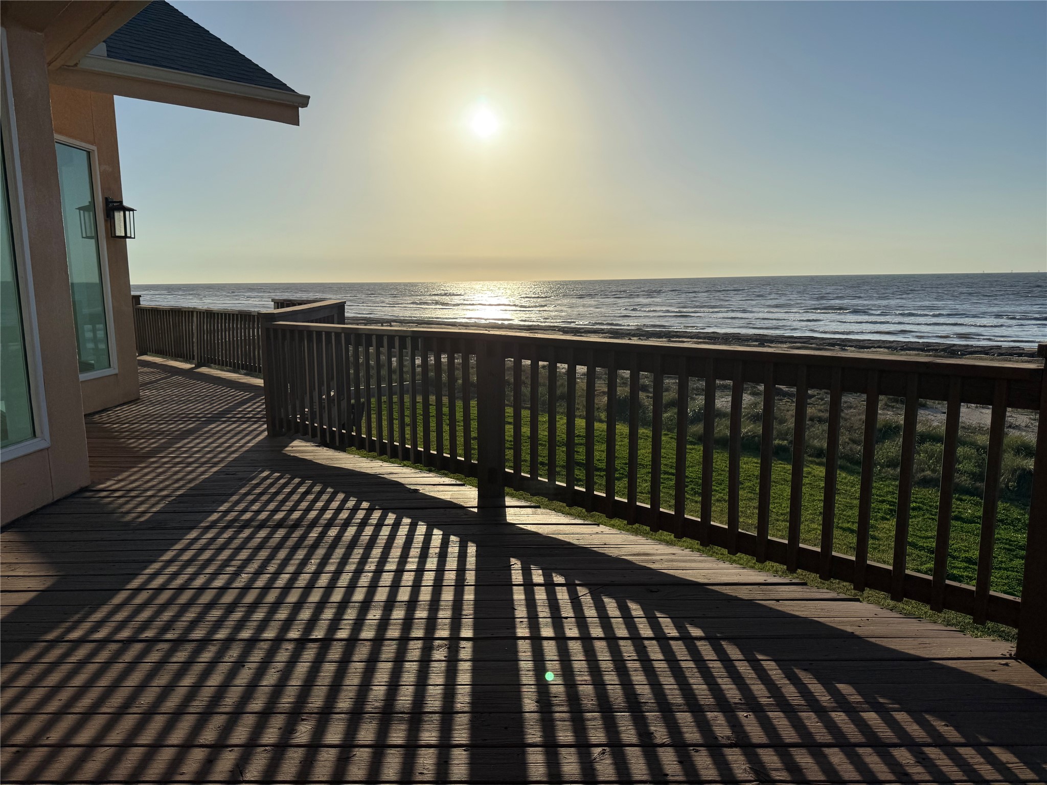 878 County Road 230 Sargent, TX 77414 - Photo 27 of 39 This photo showcases a beautiful oceanfront view from a spacious wooden deck, perfect for enjoying sunrises over the water.