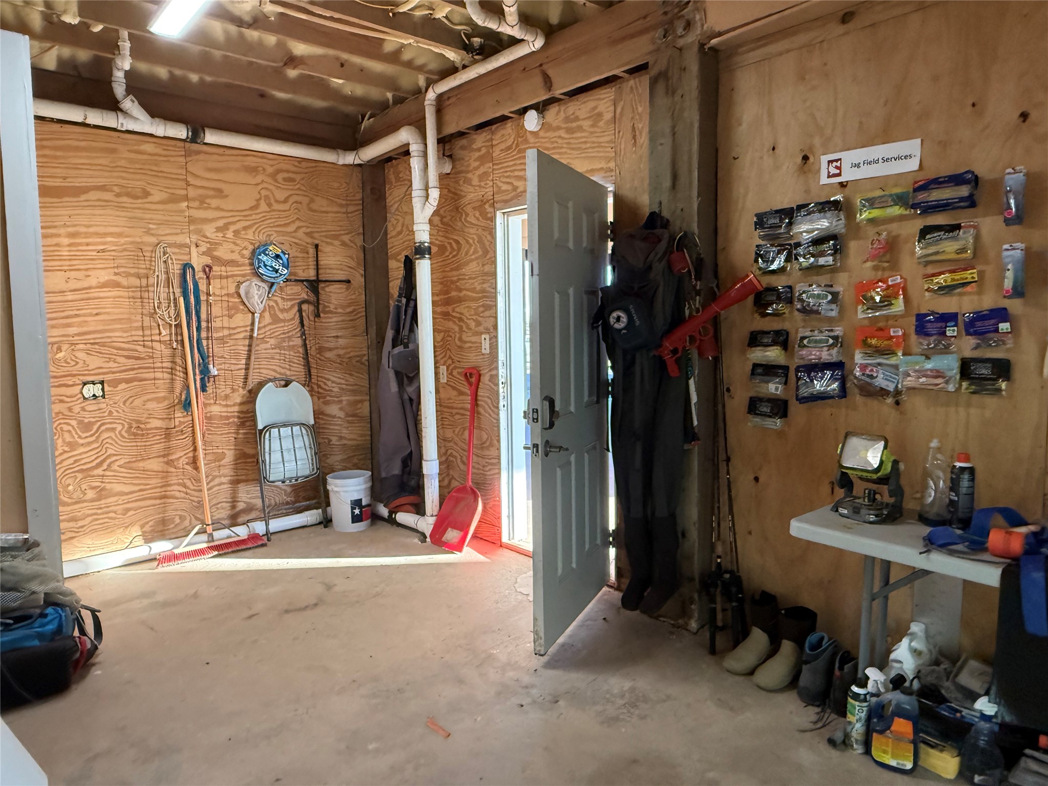878 County Road 230 Sargent, TX 77414 - Photo 35 of 39 Large storage area with a door leading outside. The space has concrete flooring, making it practical for storage or workshop use.