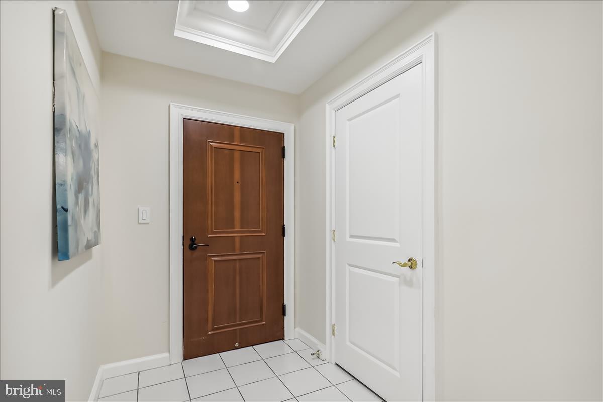 Foyer entry features guest closet, tile flooring.