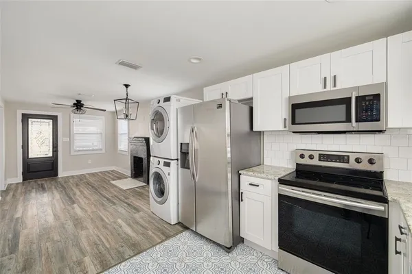 a kitchen with stainless steel appliances a stove microwave and refrigerator