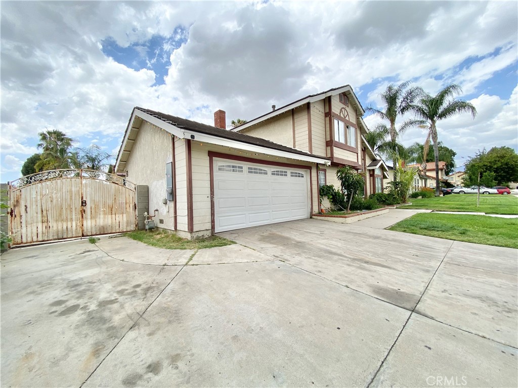 1444 North Sage Avenue Rialto, CA 92376 - Photo 4 of 22 a front view of a house with a yard and garage
