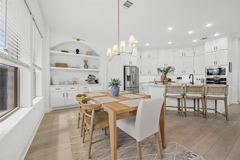 a dining room with kitchen island stainless steel appliances kitchen island granite countertop a table and chairs in it