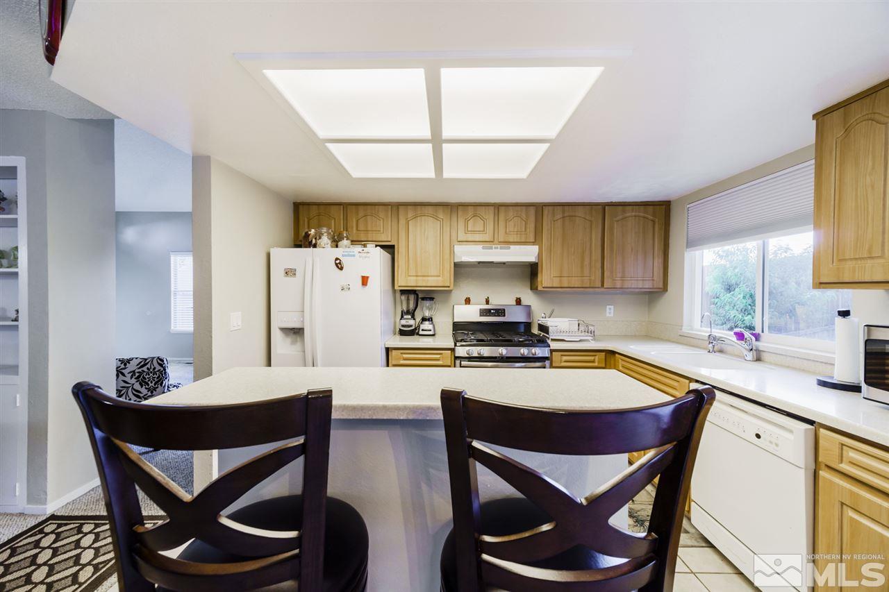 4275 Perro Lane Reno, NV 89502 - Photo 16 of 32 a kitchen with stainless steel appliances a stove a table and chairs