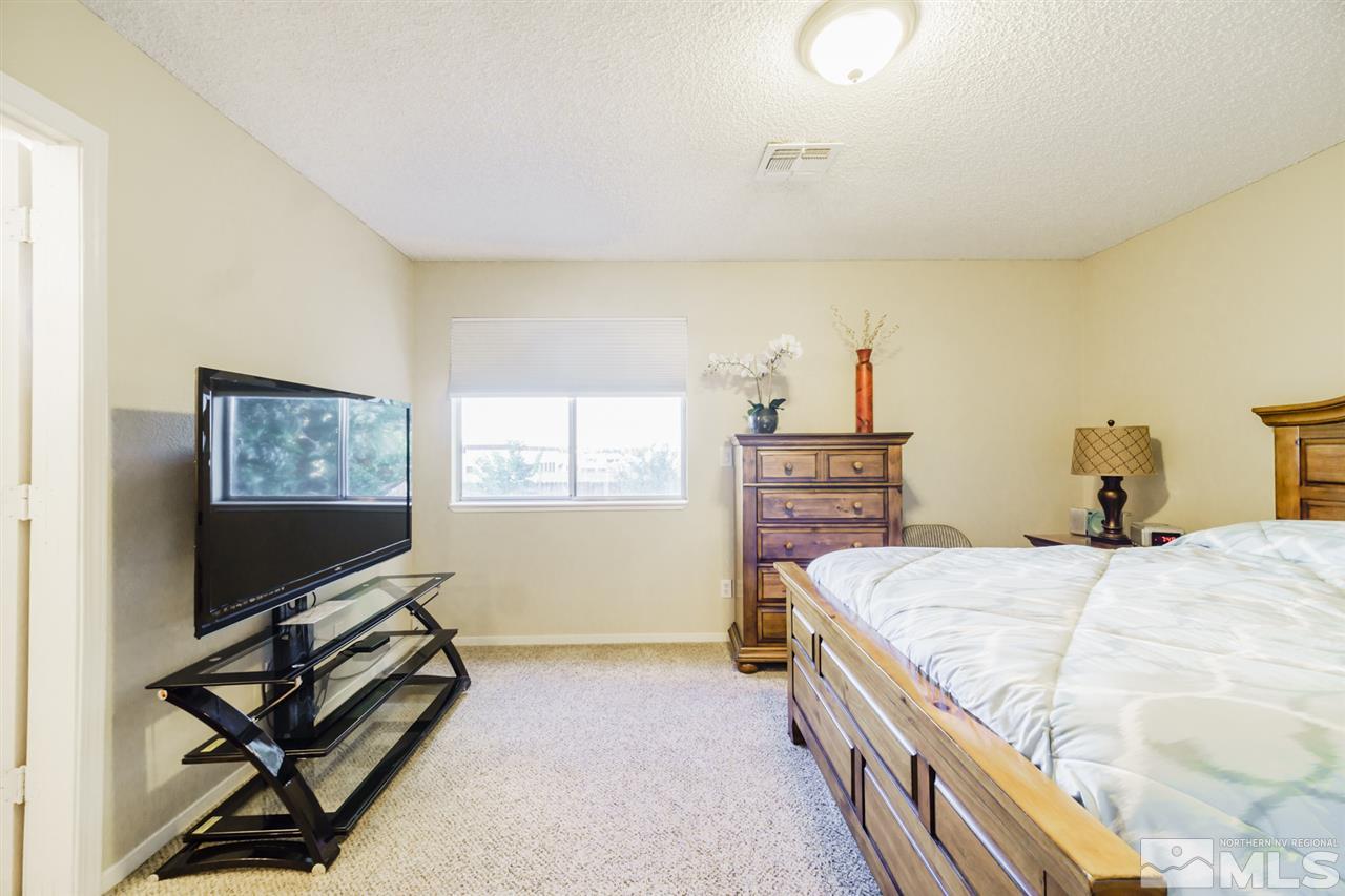 4275 Perro Lane Reno, NV 89502 - Photo 25 of 32 a bedroom with a bed and a flat screen tv