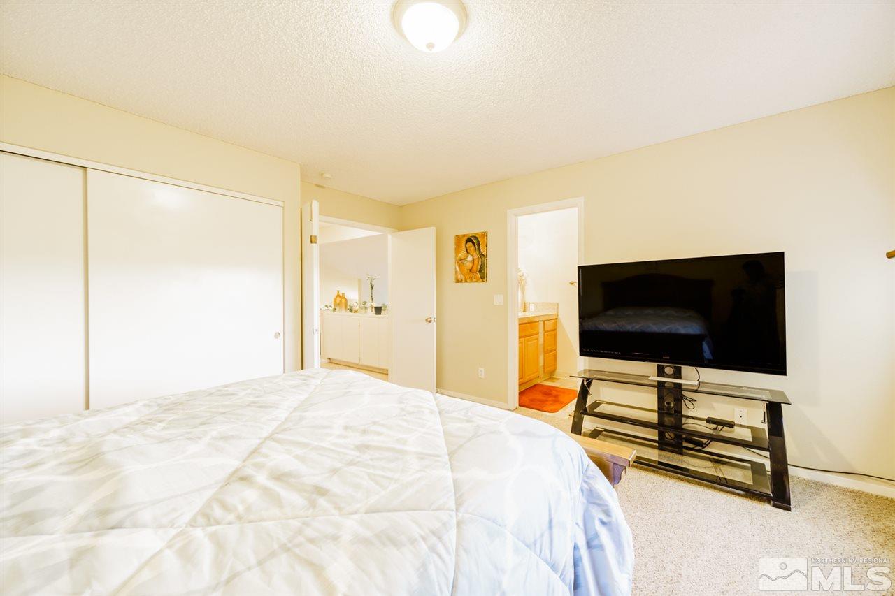 4275 Perro Lane Reno, NV 89502 - Photo 27 of 32 a bedroom with a bed and a flat screen tv