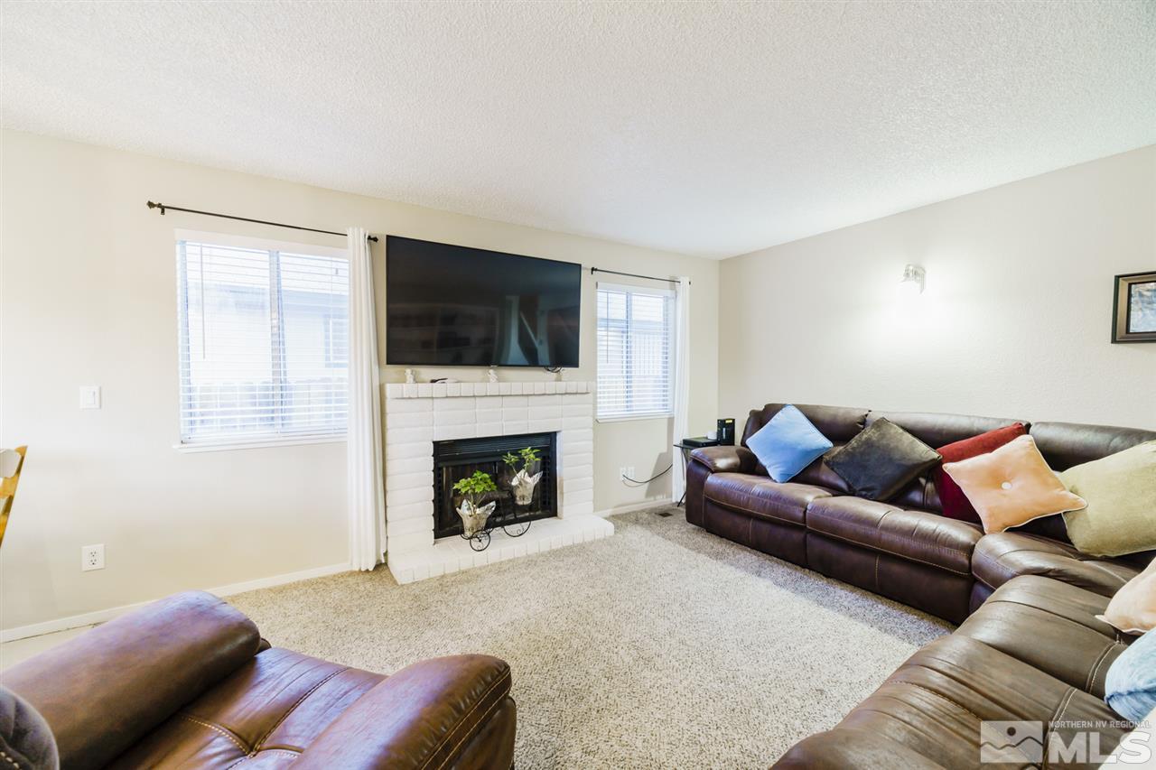 4275 Perro Lane Reno, NV 89502 - Photo 9 of 32 a living room with furniture a flat screen tv and a fireplace