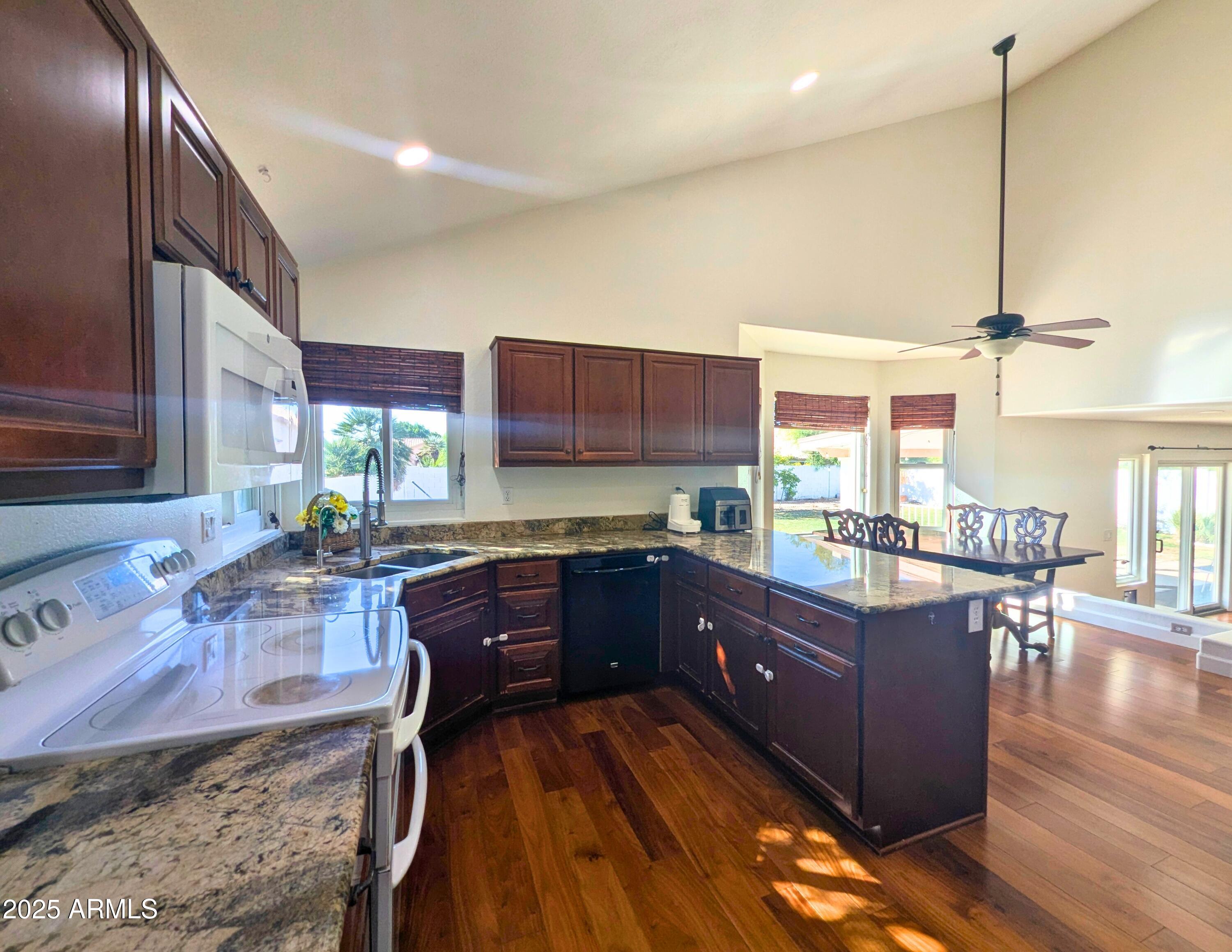 242 South Sycamore Place Chandler, AZ 85224 - Photo 16 of 40 a kitchen with stainless steel appliances granite countertop wooden cabinets a stove a sink and a wooden floors