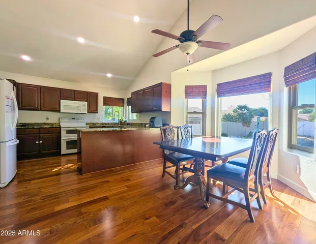 a kitchen with stainless steel appliances granite countertop wooden cabinets a stove a sink and a wooden floors