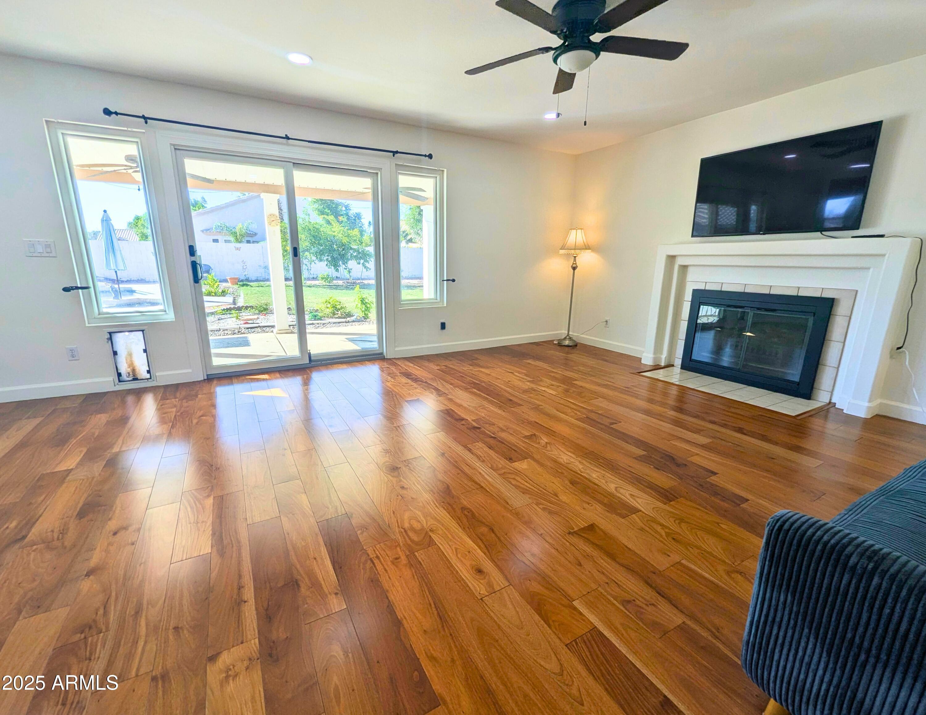 242 South Sycamore Place Chandler, AZ 85224 - Photo 19 of 40 a view of empty room with wooden floor and fireplace