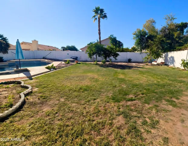 a front view of a house with a big yard and swimming pool