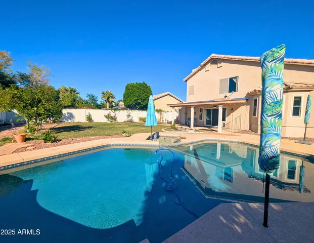 a view of a house with pool and a yard
