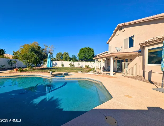 a view of a house with pool and chairs