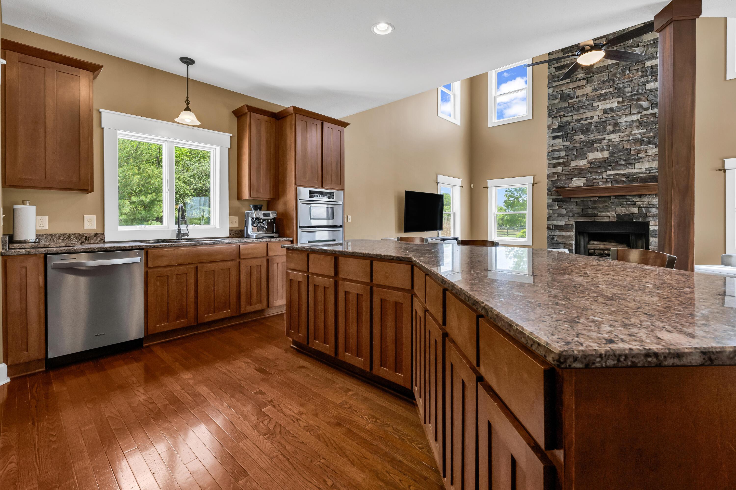 16689 Bailor Road Laurelville, OH 43135 - Photo 20 of 73 • Hardwood flooring
• Tan painted walls
• Tile backsplash
• Kenmore® 6 burner gas
stove with rangehood
(vents out)
• Center island with breakfast
bar ledge
• Double bowl, stainless steel
sink with sprayer
• KitchenAid® microwave/oven
with warming tray
• New Whirlpool® dishwasher
~ 2024
• New Samsung® refrigerator
~ 2024
• Wall pantry
• Ceiling light
• Can lighting
• Step-in pantry